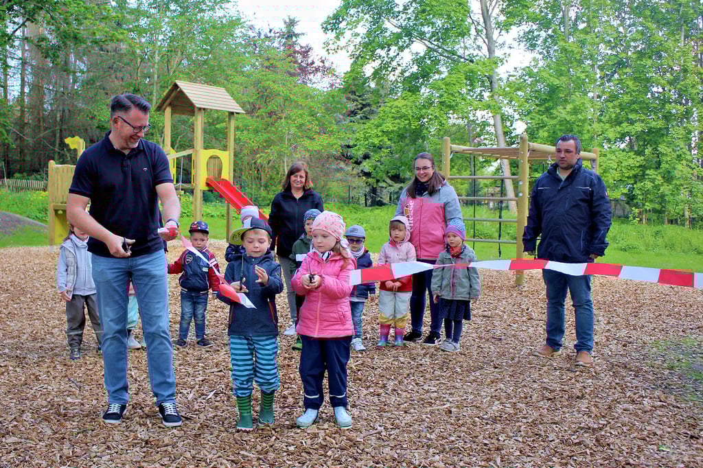 Gemeinsam mit Oliver (5) und Lilli (4) aus der örtlichen Kindertagesstätte "Parkräuber" schnitt Ortsbürgermeister Dirk Preuße das symbolische Band zur Spielplatzeröffnung durch.
