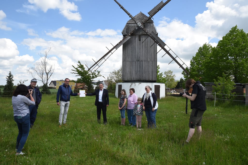 Die Pömmelter Bockwindmühle soll in diesem Jahr saniert werden. Hier bei der Übergabe des symbolischen Schecks über 30000 Euro des Landes. Ortsbürgermeister Peter Liensdorf (3.v.l.) und Kulturstaatssekretär Gunnar Schellenberger halten ihn bei einigem Medieninteresse auf Abstand ins Bild.