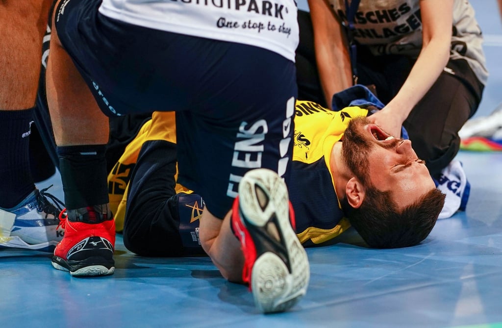 Flensburgs Benjamin Buric liegt verletzt mit schmerzverzerrtem Gesicht auf dem Spielfeld.