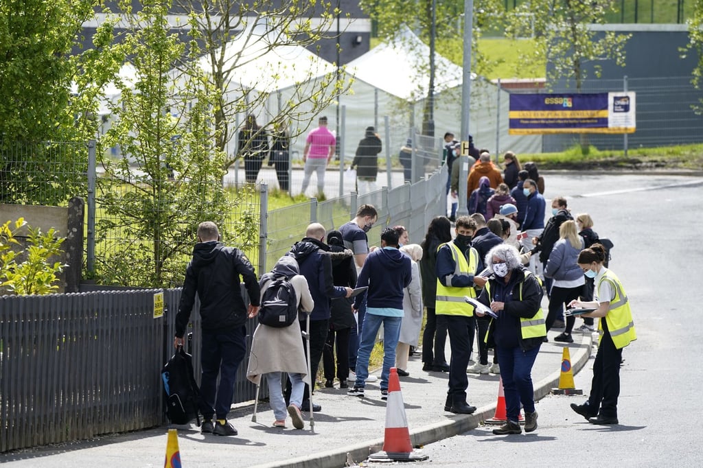 Menschen warten in einer Schlange vor dem mobilen Covid-Impfzentrum an der ESSA-Akademie in Bolton.