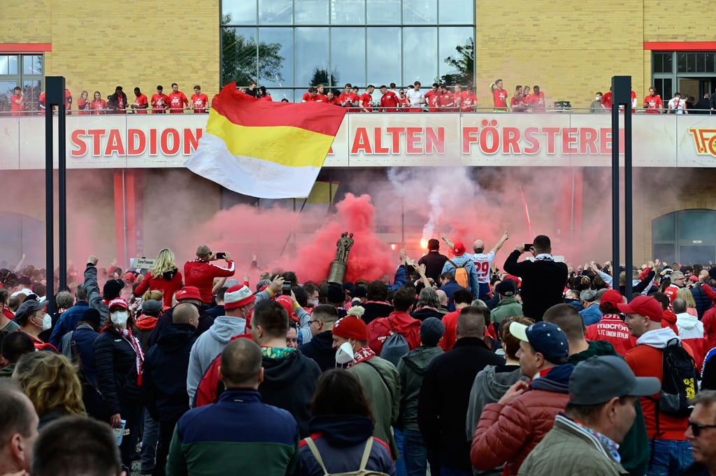 Fans von Union feiern vor dem Balkon, auf dem die Mannschaft steht, die starke Saison ihrer Mannschaft.