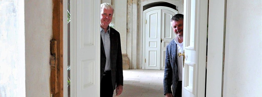 Landrat Uwe Schulze (CDU; r.) ließ sich vom Vorsitzenden des Fördervereins Schloss Zerbst, Dirk Herrmann, die neu eingebauten Türen im Eingangssaal zeigen, die nach historischer Vorlage gefertigt wurden.