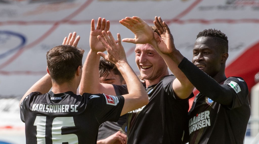 Karlsruhes Philip Heise (l-r), Robin Bormuth und Babacar Gueye jubeln. Bormuth hat das 1:0 für den KSC erzielt.