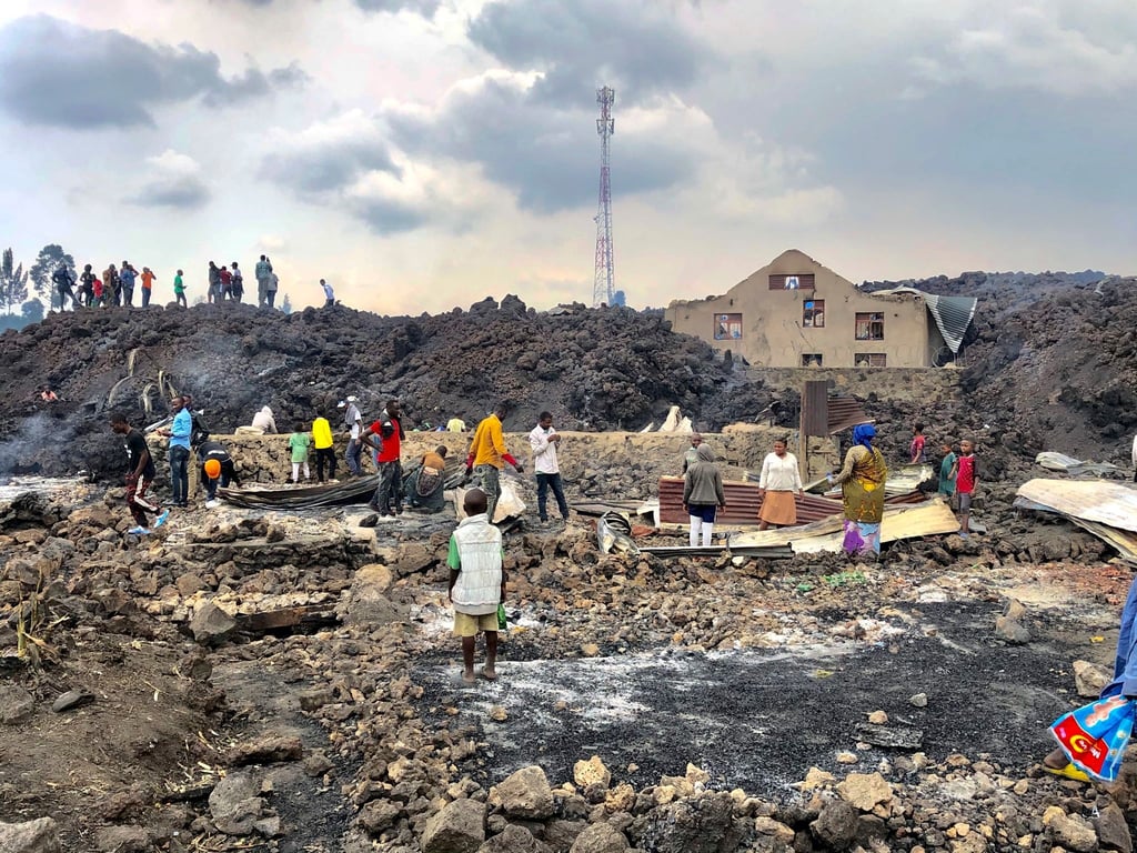 Menschen versammeln sich an einem Strom aus kaltem Lavagestein nach dem nächtlichen Ausbruch des Mount Nyiragongo in Goma.
