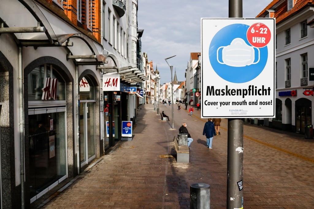 Ein Schild weist in Flensburg auf die Maskenpflicht hin.