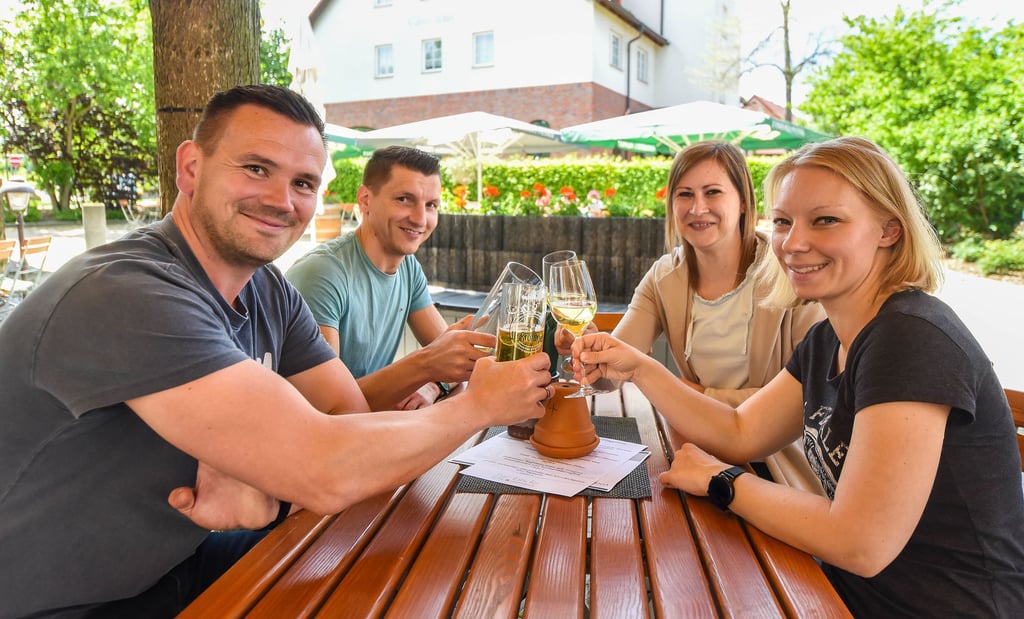 Bier und Wein gönnen sich Stefan Hesse (vorne links), seine Frau Katrin (vorne rechts) sowie seine Schwester Claudia mit Partner Kai Gora im Biergarten vom Gasthof „Zur Linde“ in Spergau.