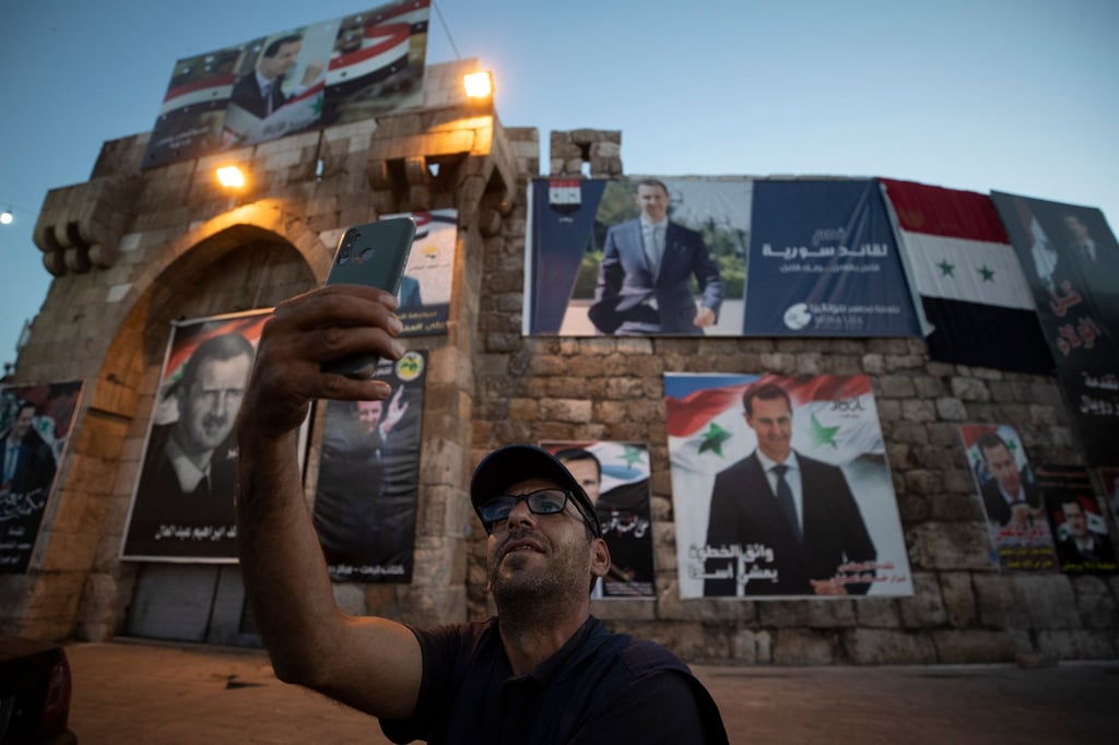 Ein Selfie vor Plakaten mit Präsident Baschar al-Assad.