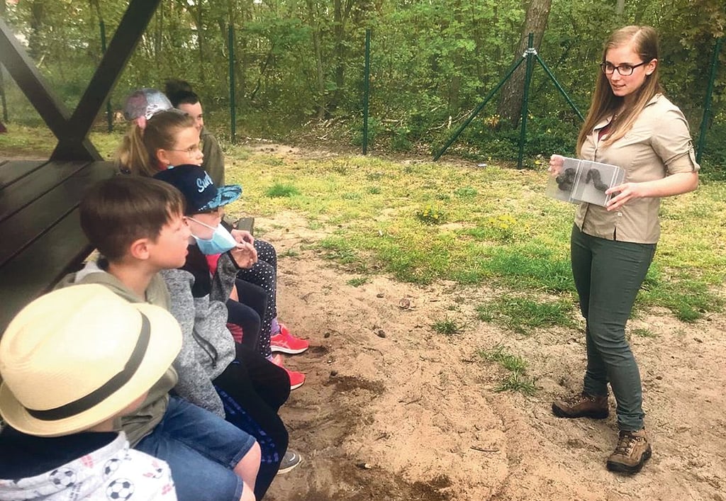 Julia Kamp zeigt den Kindern, wie die Losung vom Wolf aussieht.