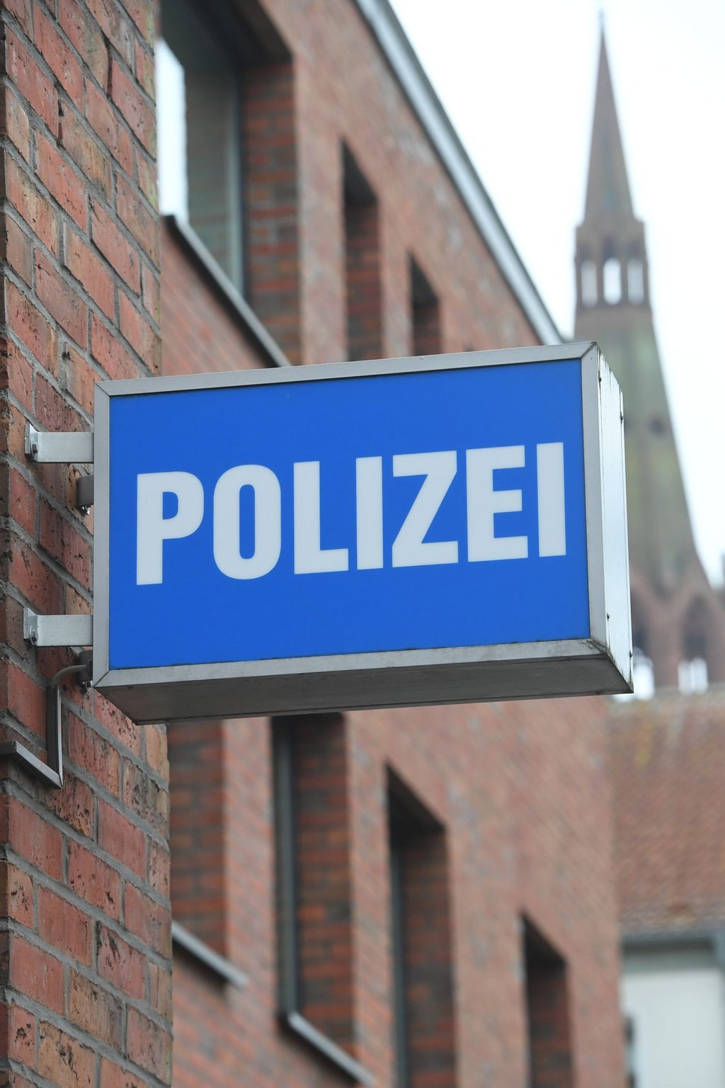 Ein Schild mit dem Schriftzug "Polizei" hängt an einer Polizeiwache.