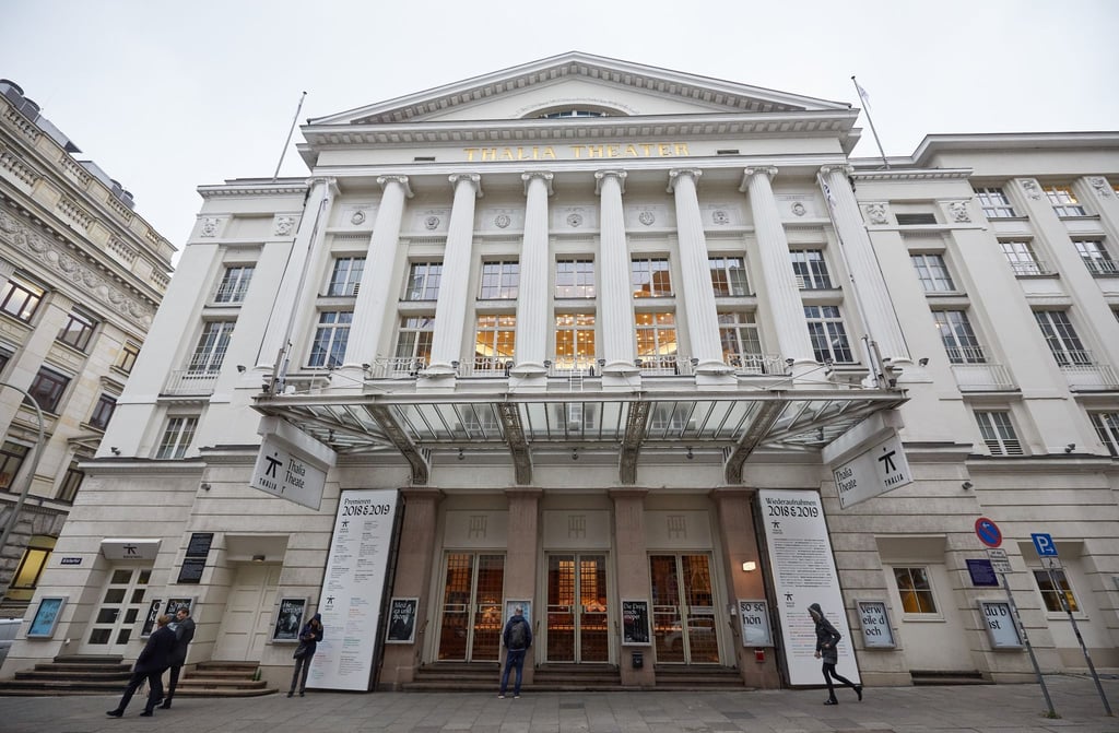 Passanten gehen am Eingang vor dem Thalia Theater vorüber.