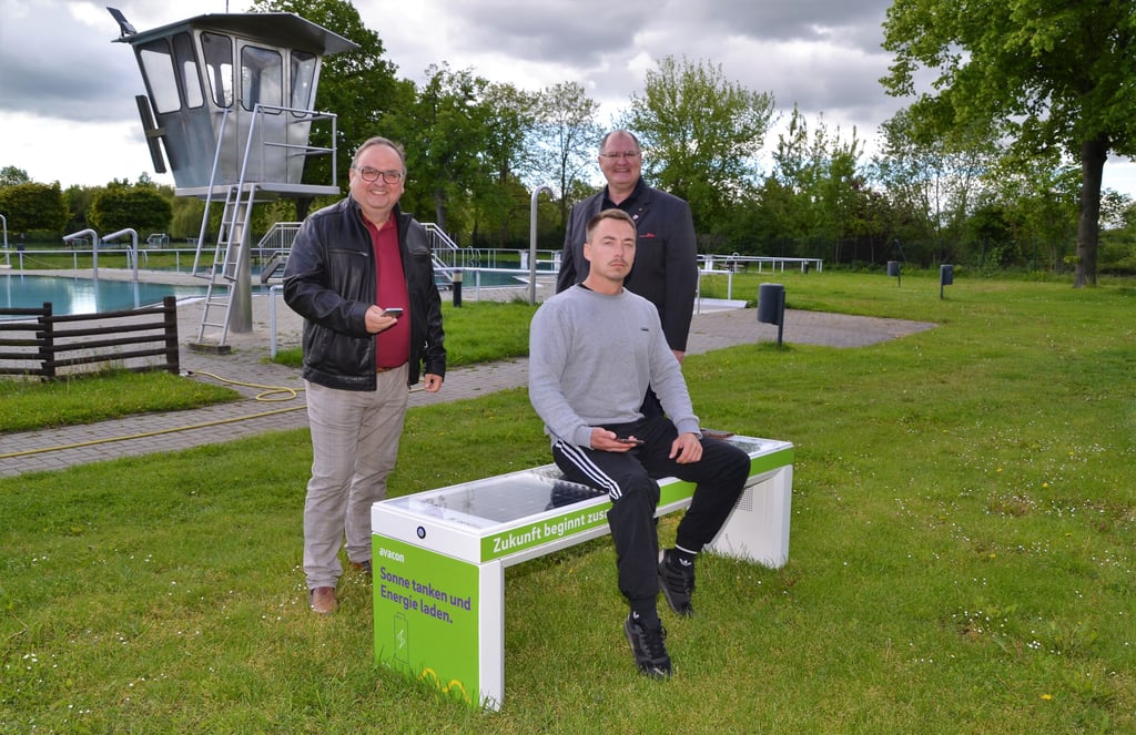 Schwimm-Meister Gino Hellrung (vorn), Ortsbürgermeister Tino Bauer und Thomas Braumann (links) testen die Solarbank.