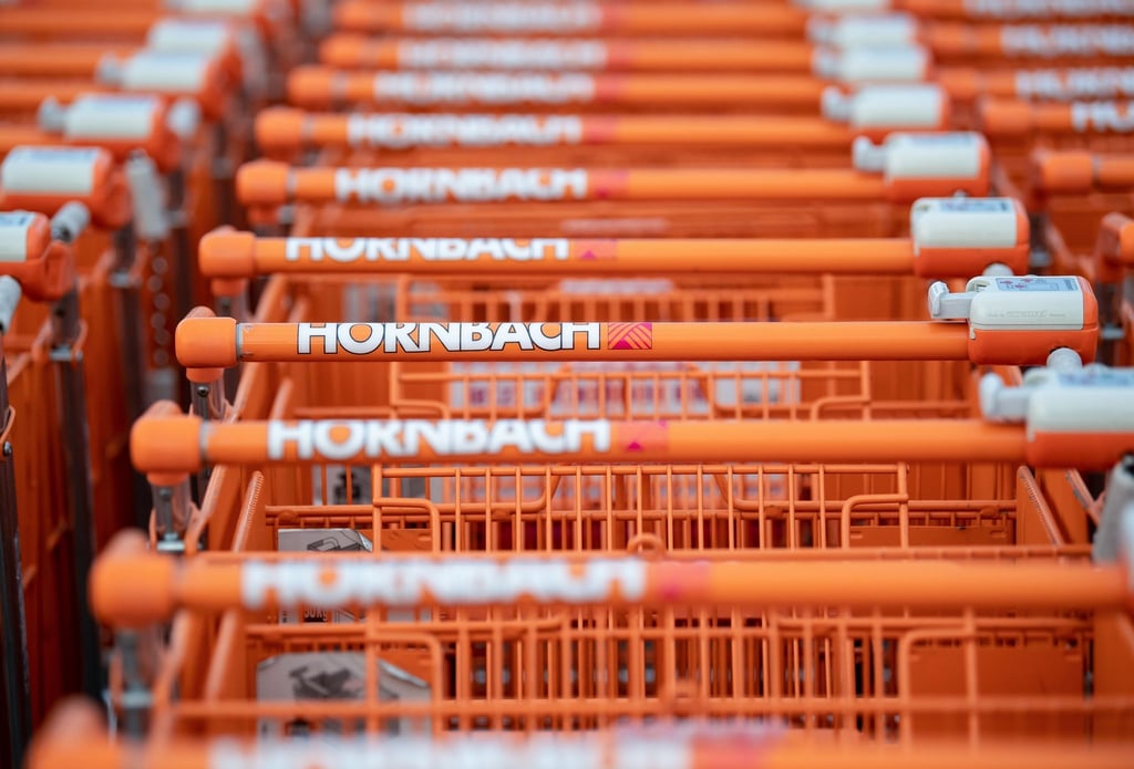 Einkaufswagen stehen auf einem Parkplatz vor einem Hornbach-Baumarkt.