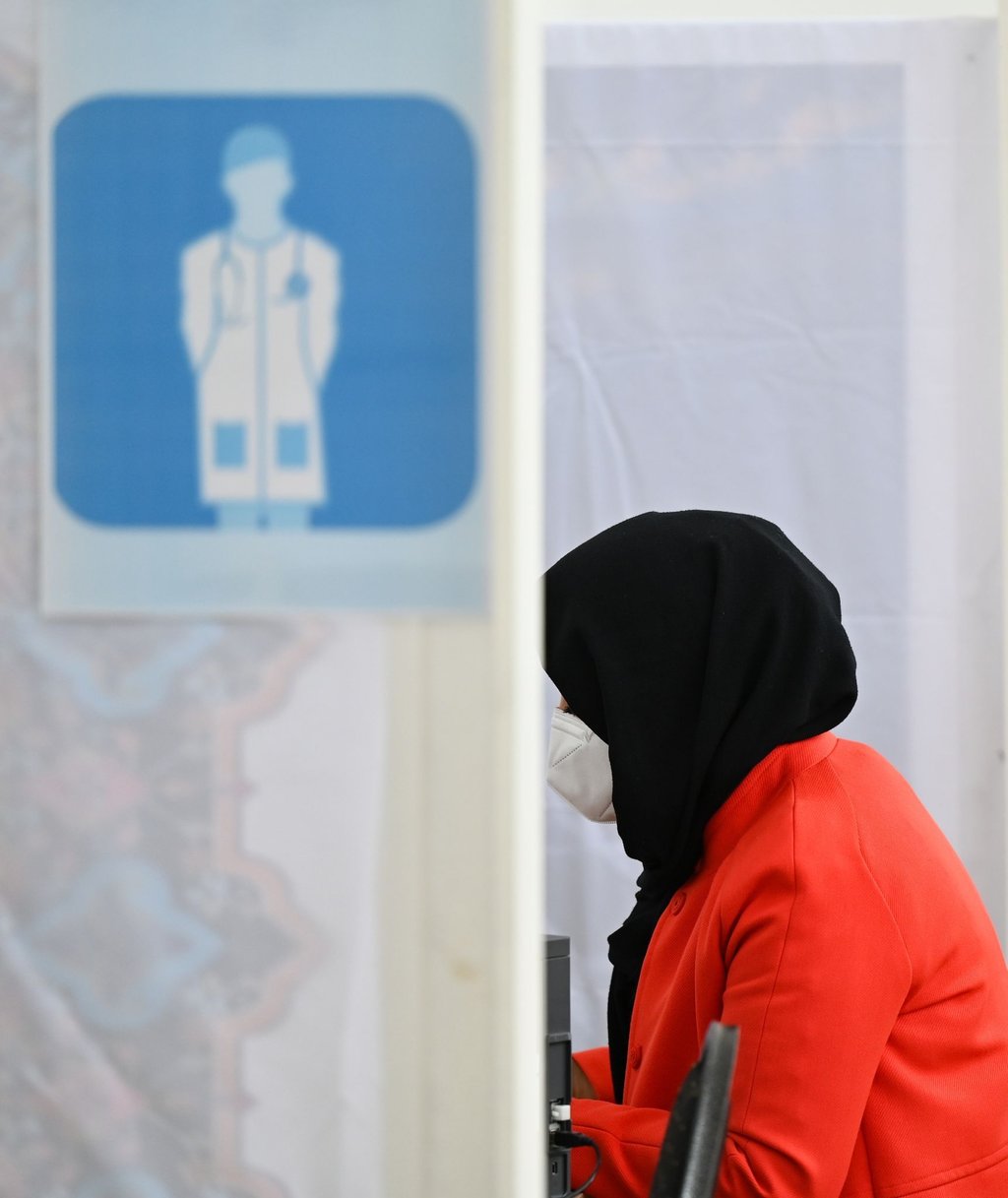 Eine Frau wird im Kulturzentrum der Imam Sadjad Moschee im Stadtteil Fechenheim über die Impfung beraten.