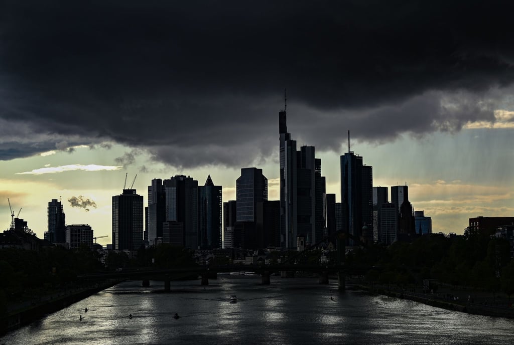 Dunkle Regenwolken ziehen am Abend über den Main und die Frankfurter Skyline hinweg.