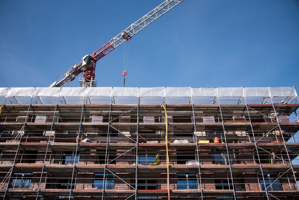 Ein Gerüst vor dem Neubau eines Mehrfamilienhaus.