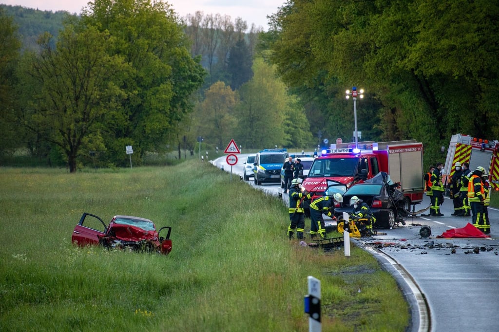 Einsatzkräfte der Feuerwehr untersuchen den Unfallort, an dem zwei Autos zusammengestoßen sind.