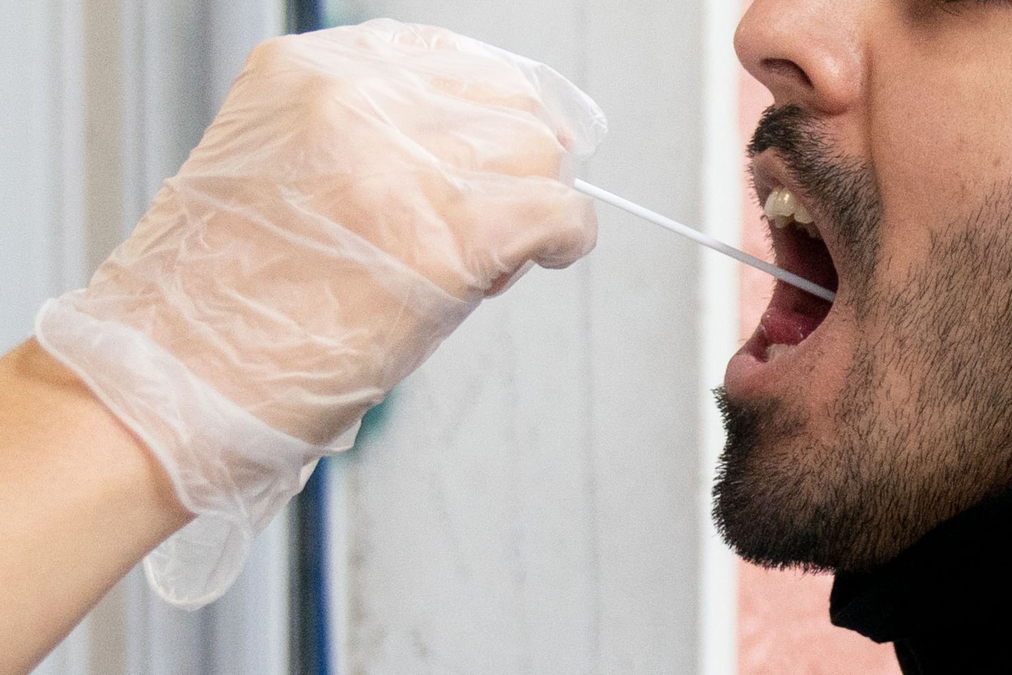 Ein Patient lässt vor einer Arztpraxis einen Abstrich machen.