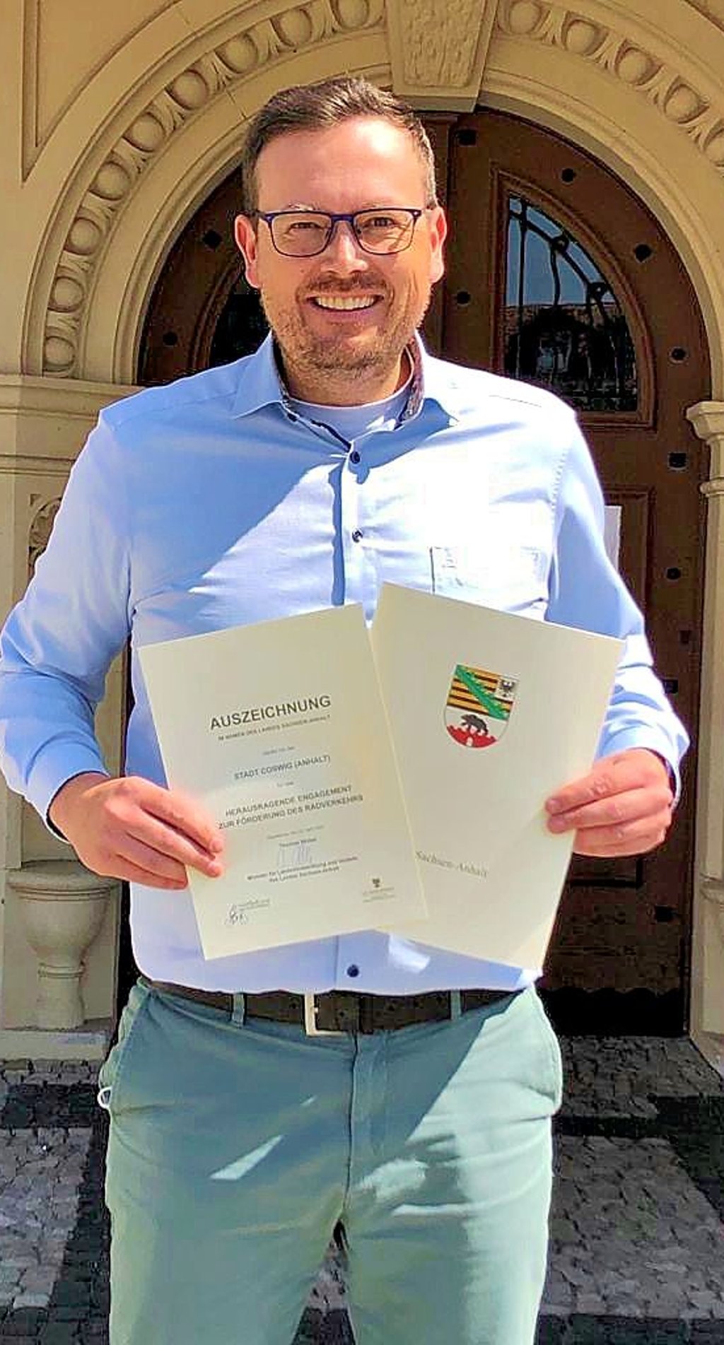 Bürgermeister Axel Clauß hält die Auszeichnung in den Händen.