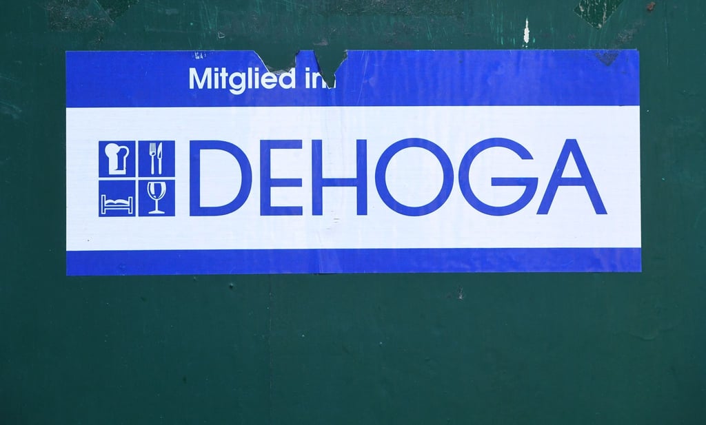 Ein Schild "Mitglied im Dehoga" klebt an der Außenwand eines Hotels.