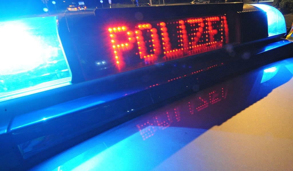 Die Aufschrift „Polizei“ leuchtet auf einem Polizeifahrzeug.
