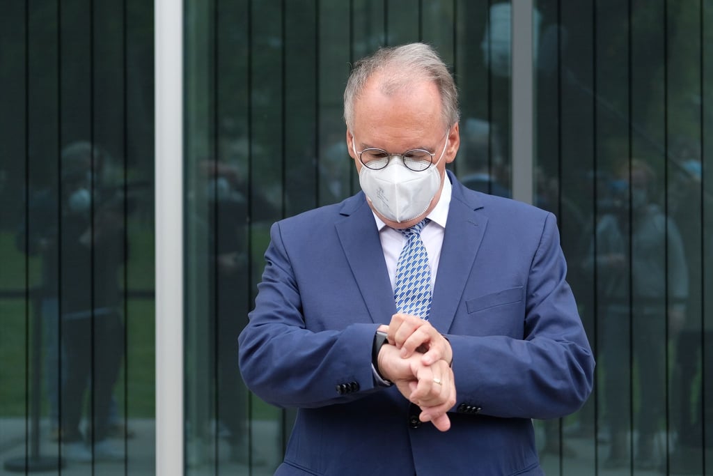 Reiner Haseloff (CDU), Ministerpräsident des Landes Sachsen-Anhalt, blickt vor dem Bauhausmuseum auf die Uhr.