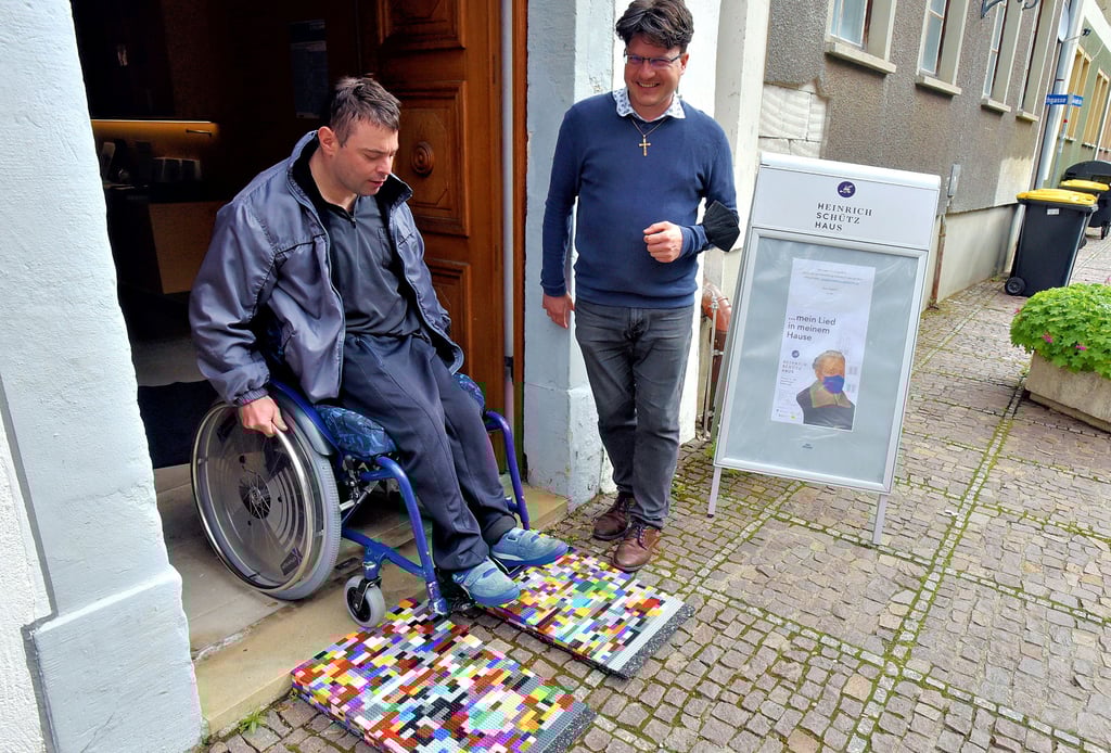 Andreas Schrudeck probiert die neue Rampe am Heinrich-Schütz-Haus aus. Maik Richter, Leiter der Gedenkstätte, beobachtet das Ganze.