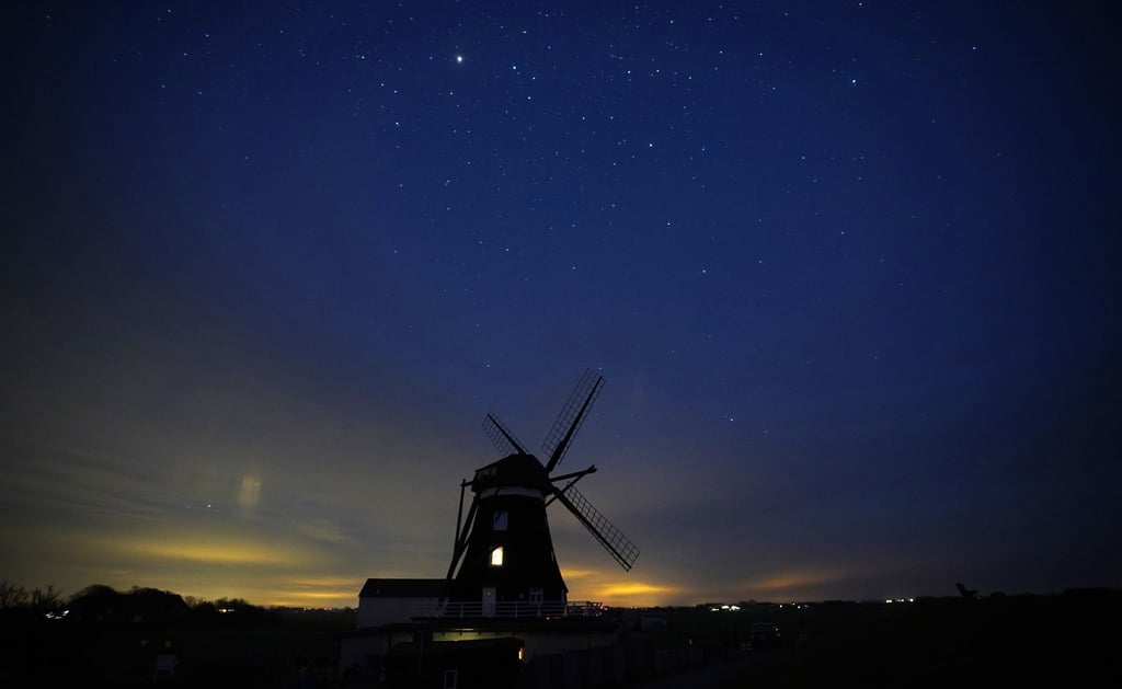 Der Sternenhimmel ist über der Nordermühle auf der Insel Pellworm zu sehen.