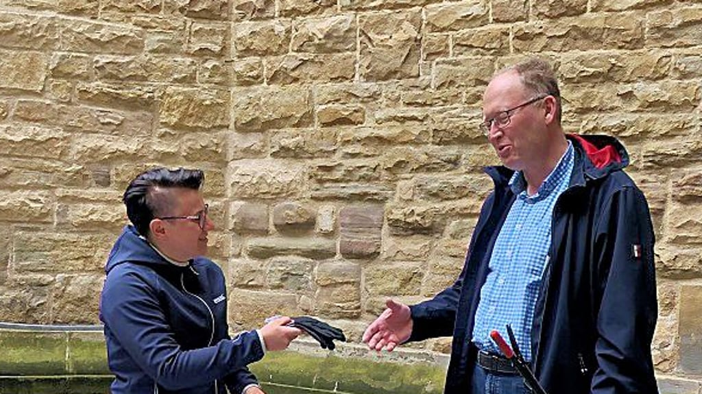 Kathrin Weber gab im Rathaushof Müllsäcke und Zangen aus, hier an Andreas Exler.