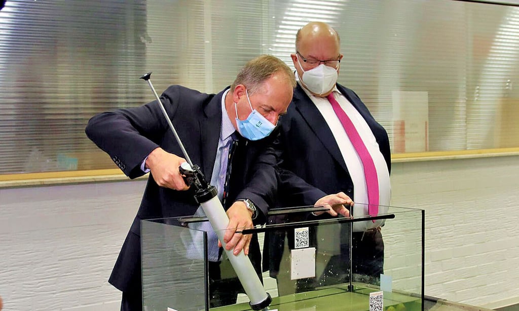 B.T. innovation-Geschäftsführer Felix von Limburg demonstriert Bundeswirtschaftsminister Peter Altmaier den innovativen Dicht- und Klebstoff InnoElast®, der unter Wasser klebt.