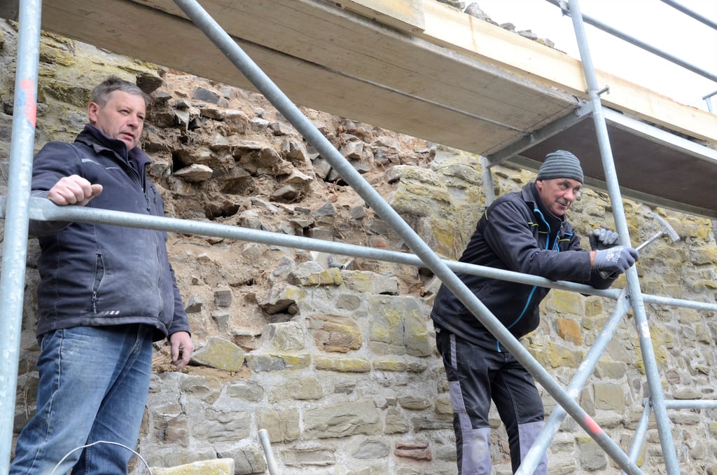 Mario Keweloh (links) und Ralf Lindecke von der Firma HDL-Bau sanieren im Auftrag der Stadt aktuell die Haldensleber Stadtmauer im Bereich des Rundwanderwegs zwischen dem Stendaler Tor und der Burgstraße. Sie müssen das Mauerwerk zum Teil neu verfugen und den Bewuchs entfernen.