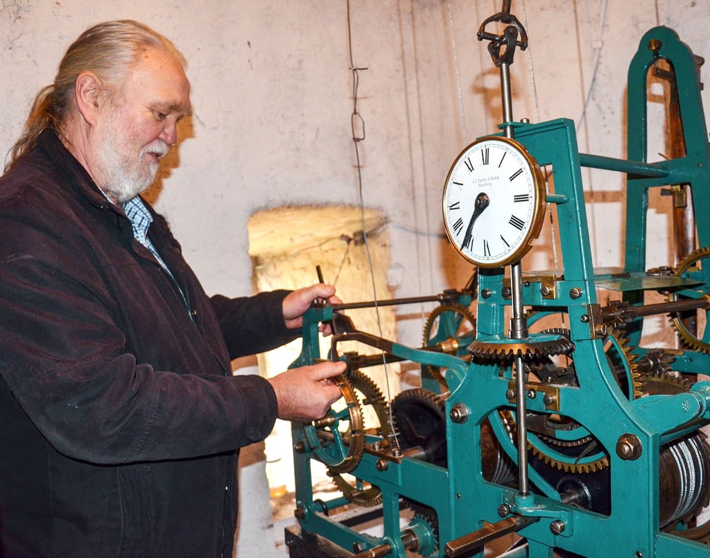 Uhrmacher Helmut Ebert erläutert die Funktionsweise der Turmuhr der Kirche in Peißen.