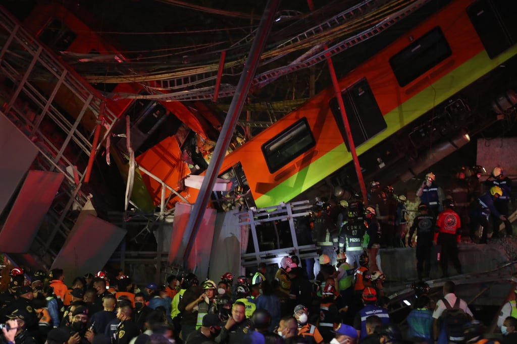 Rettungskräfte stehen am Unfallort, nachdem eine U-Bahnbrücke zum Teil eingestürzt ist.