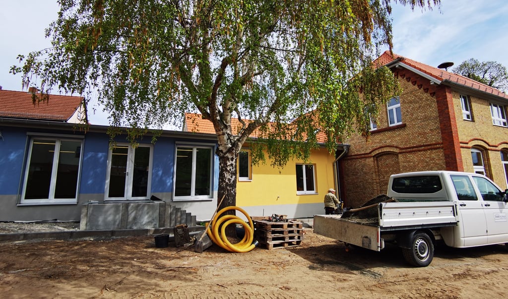 Der in blau und gelb gehaltene Krippenanbau der Kita Heimburg (links) und der Altbau aus den 1930er Jahren (rechts). Noch sind einige Restarbeiten zu erledigen. Im Juni sollen die Kinder endlich einziehen können.