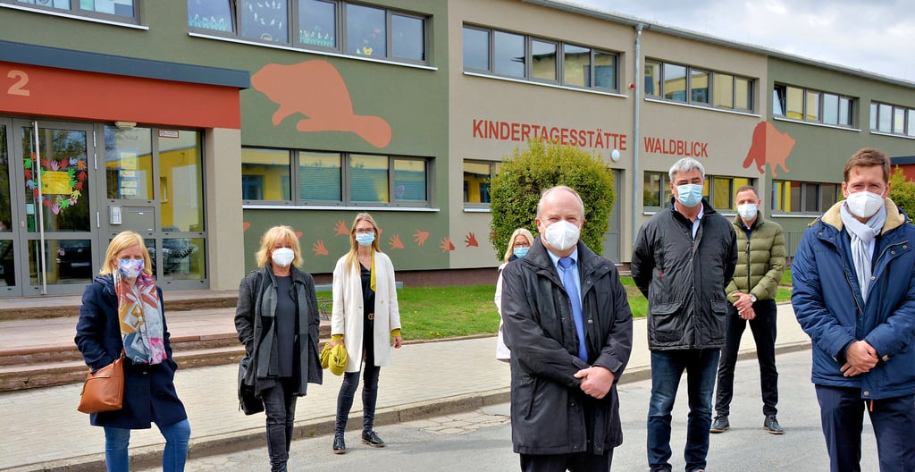 Planerin Beatrice Fischer-Liebzeit, Architektin Uschi Hülsdell, die Kita- und Krippenleiterinnen Doreen Otto und Cynthia Urban, Staatssekretär Klaus Klang (CDU), Hochbau-Abteilungsleiter Jörg Wolansky, Kita-Abteilungsleiter Thomas Fahldieck und Oberbürgermeister Daniel Szarata (CDU, von links) vor der sanierten Kita „Waldblick".