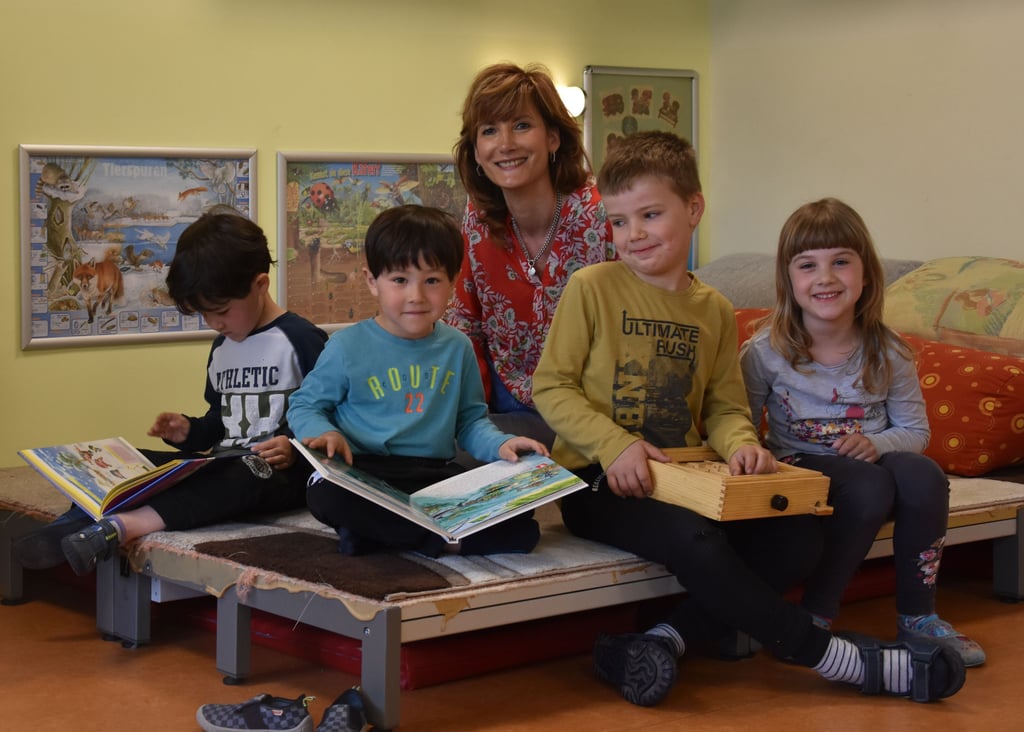 Die Lütten aus der Kita „Spielkiste" freuen sich mit Kitaleiterin Evelyn Matthias-Weber über ihre sanierte Einrichtung. Die Zwillinge Luca und Toma (5) blättern auf der Lese- und Lümmel-Liege lieber in einem Buch, während Henry (6) und Klara (5) mit Buchstaben-Würfeln spielen.