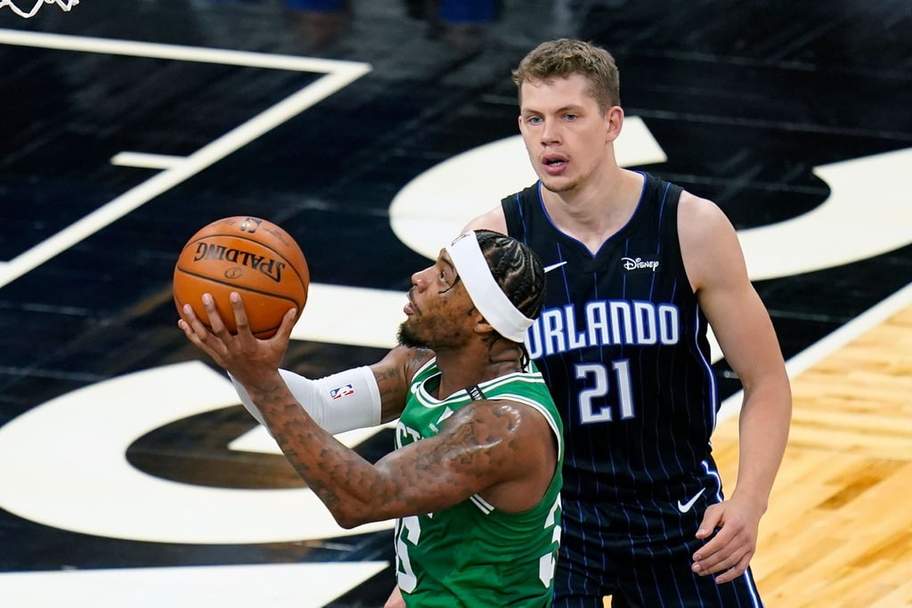 Marcus Smart (l) von den Boston Celtics setzt zum Wurf an. Moritz Wagner (21), Spieler bei Orlando Magic, versucht ihn zu decken.