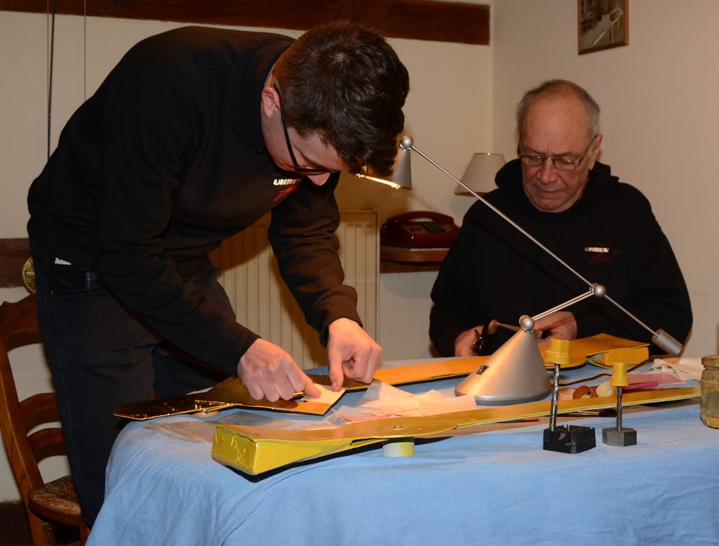 Uhrmachermeister Günther Haut schaut seinem Enkel Carl Robra beim Vergolden der Turmuhrzeiger ganz genau auf die Finger und gibt Tipps für den Zuschnitt der feinen Blätter.