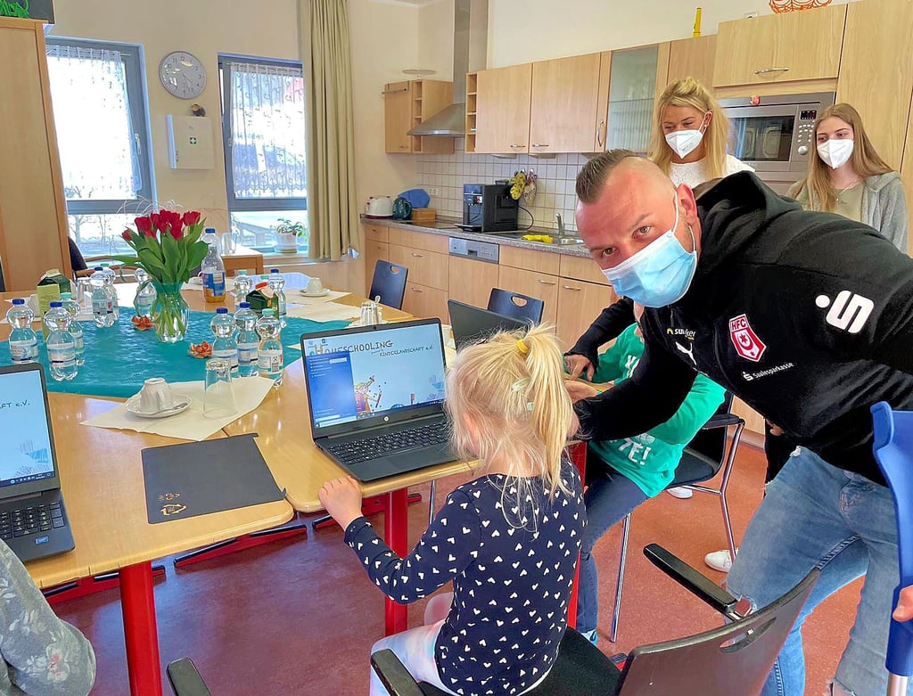 HFC-Profi Toni Lindenhahn überreicht die Laptops an die Kinder.