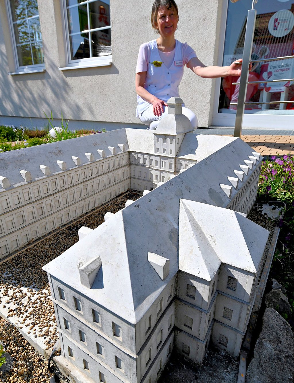 Annett Wenzel, Inhaberin der Weißenfelser West-Apotheke, zeigt das Modell von Schloss Neu-Augustusburg in ihrem Vorgarten.