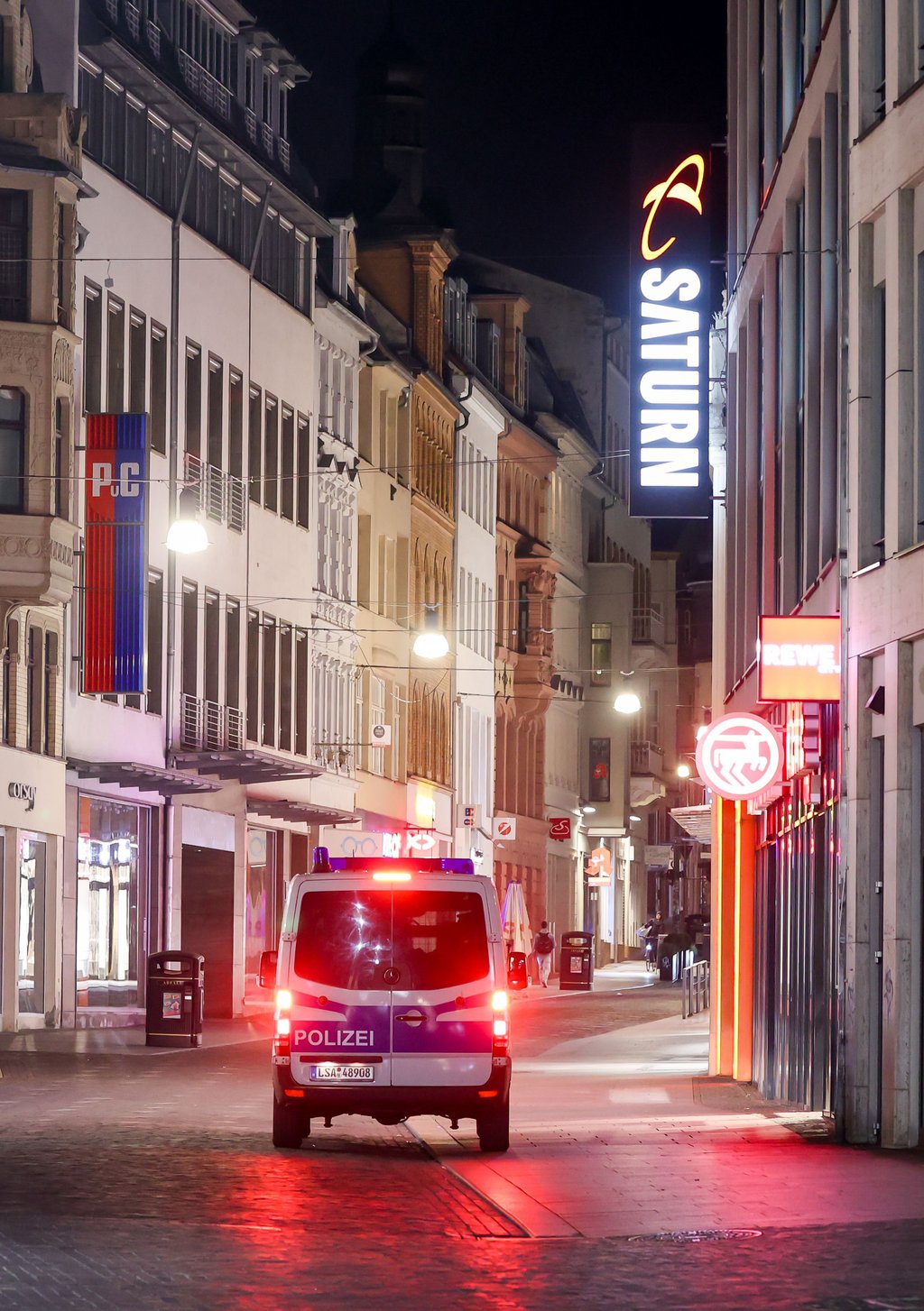 Ein Polizeifahrzeug fährt in den Abendstunden durch die Innenstadt von Halle (Saale).