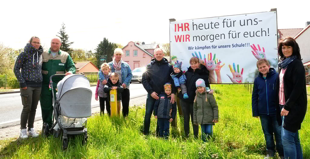 Auch Eltern wie Nancy Stuhlmacher (4. von rechts), deren Kinder erst zukünftig die Grundschule besuchen werden, kämpfen für deren Erhalt. Am Freitag wurden Banner an allen drei Ortseingängen angebracht – hier in der Havelberger Straße.