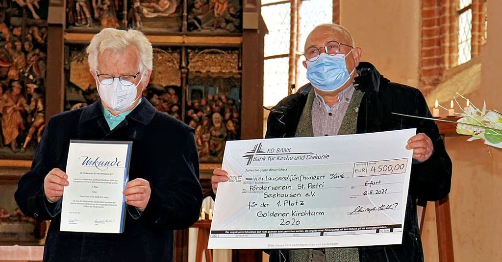 Reiner Krainz (v.l) und Walter Fiedler vom St. Petri-Förderverein halten stolz die Urkunde und den symbolischen Scheck in Händen.
