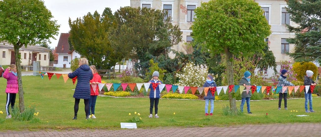 Die Grundschüler brachten auf der Wiese vorm Rathaus eine selbstgebastelte Wimpelkette an.