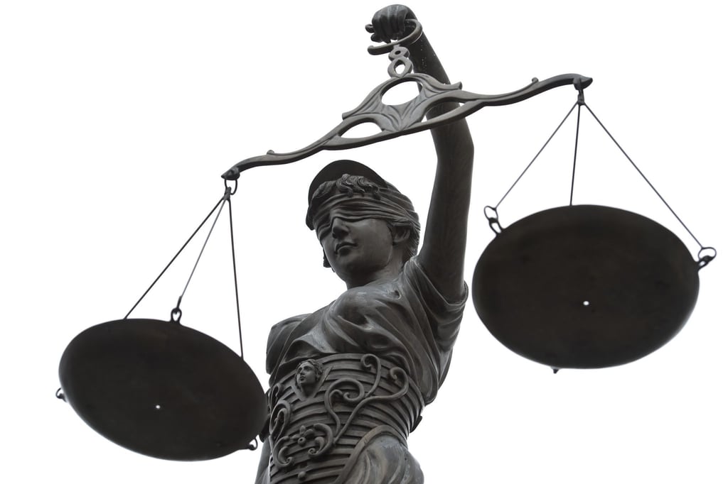 Eine Statue der Justitia mit einer Waage in ihrer Hand.