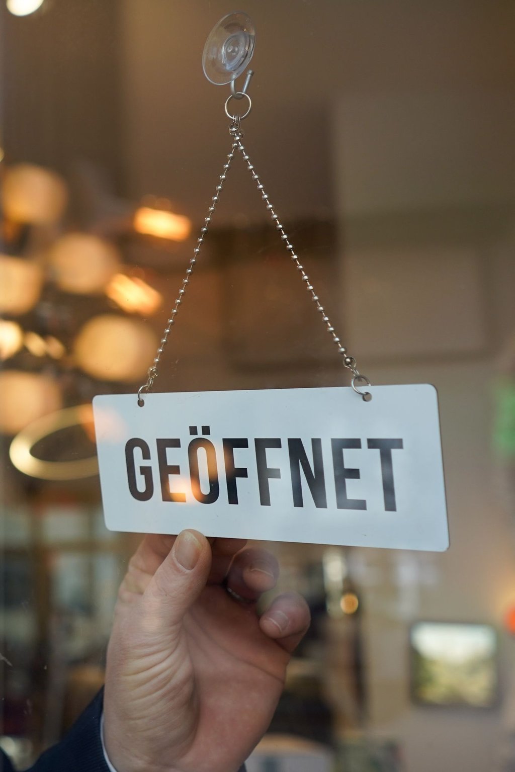 Ein Wendeschild mit der Aufschrift "geöffnet" wird umgedreht.