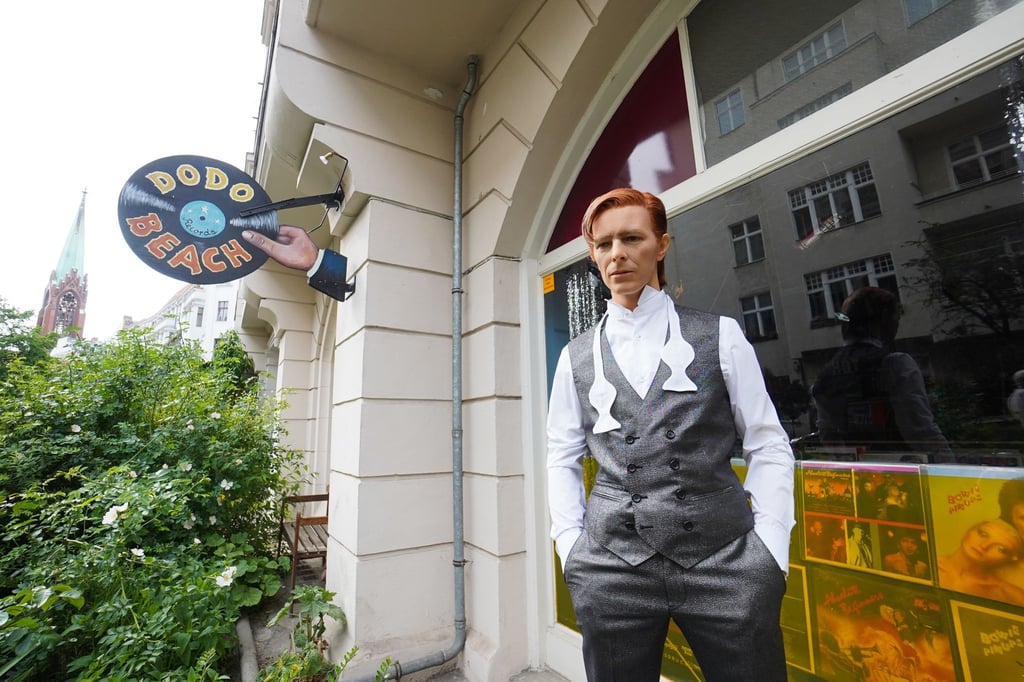 Die Wachsfigur von David Bowie steht vor einem Schallplattenladen.