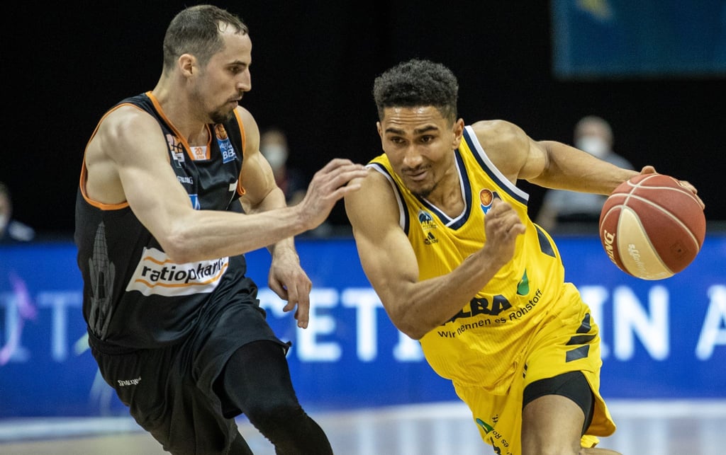 John Petrucelli von ratiopharm Ulm kämpft gegen ALBAs Maodo Lo (r) um den Ball.