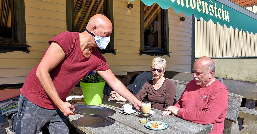 Harald van Antwerpen vom Hotel Druidenstein in Trautenstein (links) serviert Cordia und Rainer Oeser Kaffee und Kuchen.