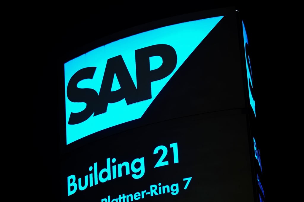 Ein von innen beleuchtetes Logo des Softwarekonzerns SAP steht vor einem Firmengebäude.