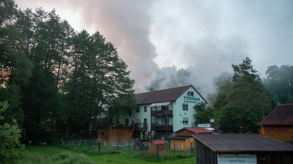 Einsatzkräfte der Feuerwehr gehen an einem Gebäude des Tierheims entlang. Bei einem Brand in einem Tierheim in Unterfranken sind mehr als 60 Tiere ums Leben gekommen.